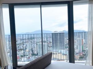 een kamer met een bed en uitzicht op de stad bij Panorama Apartment Sunset Nha Trang City in Nha Trang