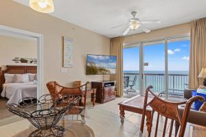 a living room with a bed and a view of the ocean at Sunrise Beach Resort 1205 - Paradise Found in Panama City Beach