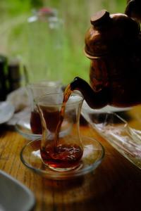 a teapot pouring tea into a cup on a table at Sumda Konaklar in Çamlıhemşin