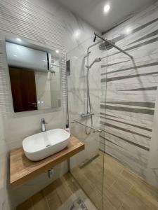 a bathroom with a sink and a glass shower at *HOT* Main Square Brand New Luxury Apartment in Burgas City +15 photos