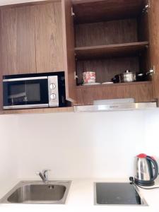 a kitchen with a sink and a microwave at Panorama Apartment Sunset Nha Trang City in Nha Trang