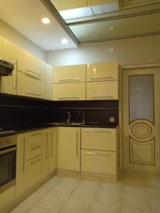 uma cozinha com armários brancos e um lavatório em 3-комн. апартаменты в районе Болашак em Qyzylorda