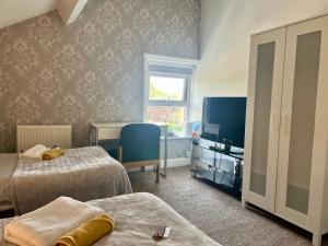 ein Hotelzimmer mit 2 Betten und einem TV in der Unterkunft St Andrews house Hotel in Preston