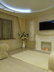 a living room with a fireplace and a tv at 3-комн. апартаменты в районе Болашак in Qyzylorda