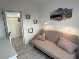 una sala de estar con sofá y una pintura en la pared en Apartament Costinești vedere epavă, en Costinesti