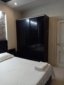 a bedroom with a large black cabinet with towels on a bed at 3-комн. апартаменты в районе Болашак in Qyzylorda +15 photos