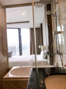 a bathroom with a sink and a bed and a mirror at Panorama Apartment Sunset Nha Trang City in Nha Trang
