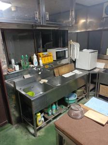 a kitchen with a sink in the middle of it at Minshuku Kamagari in Kure