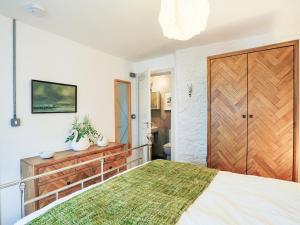 a bedroom with a large bed and a wooden door at The Old Stables in Totnes