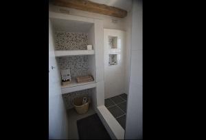 a bathroom with a walk in shower with shelves at Msasa Views Cottage in Juliasdale