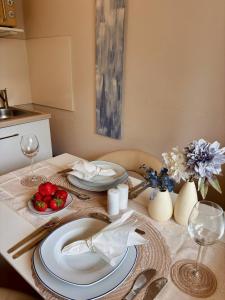 una mesa con platos y vasos encima en Stylish studio apartment with terrace, en Ingolstadt