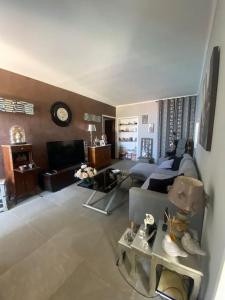 a living room with a couch and a clock on the wall at Maison en bord de mer en Corse Lavasina Brando in Brando +22 photos