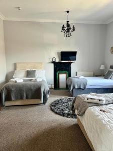 a bedroom with two beds and a fireplace at St Andrews house Hotel in Preston
