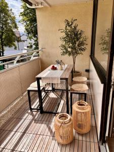 a table and two chairs on a balcony with a tree at Stylish studio apartment with terrace in Ingolstadt