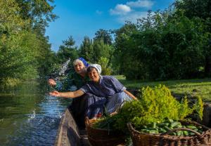 two women are in a boat on the water at Spreewald Pension Am Spreeschlößchen in Lübbenau