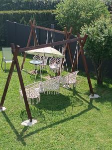 a swing set in a yard with a table and chairs at Apartma pri Renati in Celje