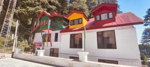 a building with a colorful roof on top of it at Sheesha cottage in Patnitop