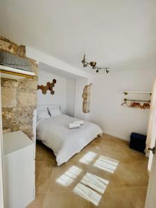 um quarto com uma cama branca e uma parede de pedra em Casa Modesta- Terrace apartent with stunning view em Lledó