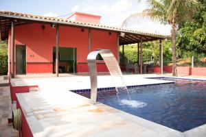 uma piscina com uma fonte em frente a uma casa em Rancho Ponta do Sol em Capitólio