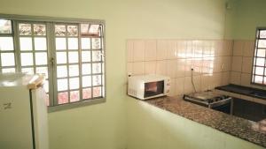 uma cozinha com um micro-ondas branco num balcão em Rancho Ponta do Sol em Capitólio