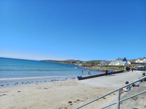een uitzicht op een strand met mensen en de oceaan bij Lavender lane cottage in Tralee