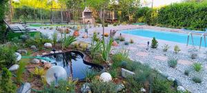 um jardim com piscina e um lago com plantas em Villa IHOR- Private Pool Villa -Pieria em Plaka Litochorou