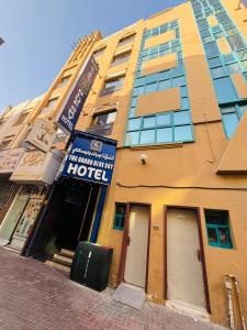 a yellow building with a hotel sign on it at The Grand Blue Sky in Dubai