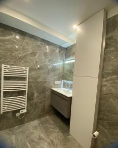 ein Bad mit einem Waschbecken und einem Spiegel in der Unterkunft Superbe Appartement Hypercentre climatisé in Cannes