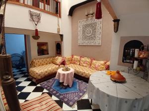 sala de estar con sofá y mesa en Riad Dar Lemdrssa, en Fez