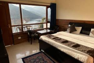 een slaapkamer met een bed en een balkon met uitzicht bij Goroomgo Rohila Lodge Nainital Near Naini Lake - Luxury Room Mountain View in Nainital