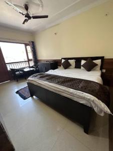 een slaapkamer met een groot bed in een kamer bij Goroomgo Rohila Lodge Nainital Near Naini Lake - Luxury Room Mountain View in Nainital