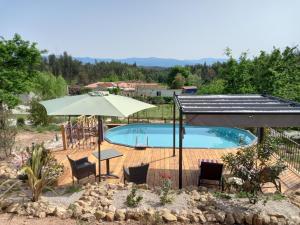 a swimming pool with a table and umbrella and chairs at Villa Tranquilla apartment in Oliveira do Hospital