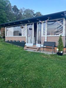 a screened in porch of a house with a yard at Glamping Karavan in Chrášťany