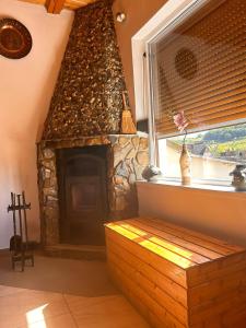 a stone fireplace in a living room with a window at Rustic in Mediaş