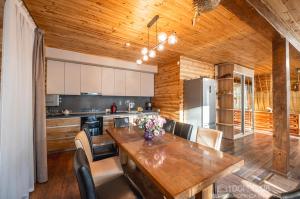 eine Küche mit einer Holzdecke und einem Holztisch in der Unterkunft Дом на берегу in Protsev