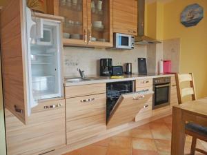a kitchen with wooden cabinets and a sink and a microwave at Ferienhaus Mandy in Wohlenberg