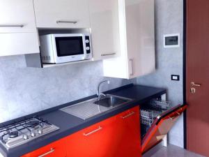 a kitchen with a sink and a microwave at Comfortable flat in a fantastic location - Beahost in Bibione