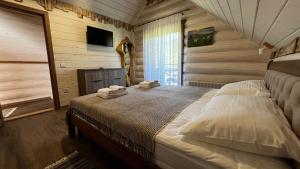 a bedroom with a bed with towels on it at Садиба Кичера та Кичера Еко in Mizhhirʼʼya