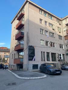 ein Gebäude mit einem davor geparkten Auto in der Unterkunft Vintage Apartment in Pristina
