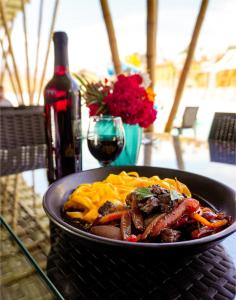 un plato de comida en una mesa con una botella de vino en Hotel Gran Marquez, en Moquegua