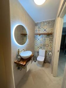 uma casa de banho com um lavatório, um WC e um espelho. em Casa Modesta- Terrace apartent with stunning view em Lledó