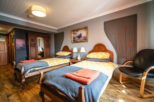 a bedroom with two beds and a chair at Burnside Cottage in Wick