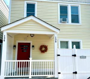 una casa con una puerta roja y una valla blanca en 9-A Diamond in Yonkers, NY, en Yonkers