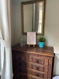 a dresser in a room with a mirror at The Olde Swan Hotel in Chertsey