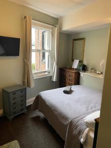 a bedroom with a bed and a window at The Olde Swan Hotel in Chertsey