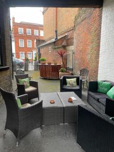 a patio with couches and chairs and a table at The Olde Swan Hotel in Chertsey
