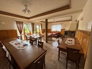 a kitchen and dining room with wooden tables and chairs at Villa Szarotka in Dzianisz