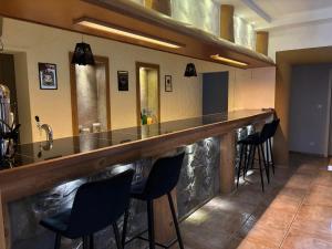 a bar in a room with chairs around it at Villa Szarotka in Dzianisz