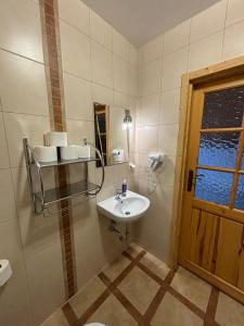 a small bathroom with a sink and a window at Villa Szarotka in Dzianisz