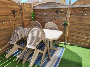 a group of chairs around a table on a patio at F2 50m de la mer avec parking privé in Valras-Plage